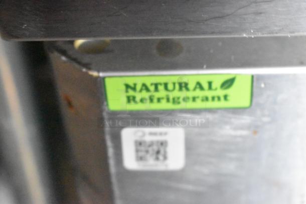 Green "NATURAL Refrigerant" sticker on stainless steel surface, indicating eco-friendly cooling technology.