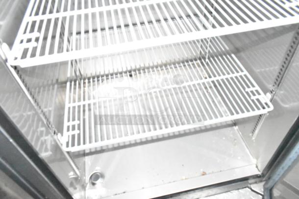 Interior of brand new Wendy's mobile kitchen trailer refrigeration unit with metal wire shelves, clean and unused condition.