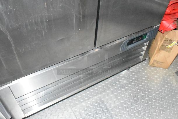 Stainless steel refrigeration unit inside a brand new Wendy's mobile kitchen trailer on a diamond plate floor.