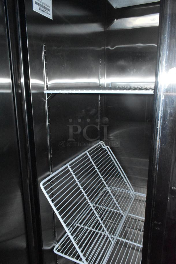 Interior of fully equipped mobile kitchen trailer, featuring shelving in pristine condition.