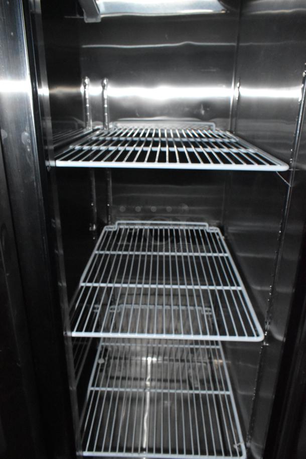 Industrial stainless steel shelving inside a new mobile kitchen trailer, featuring wire racks.