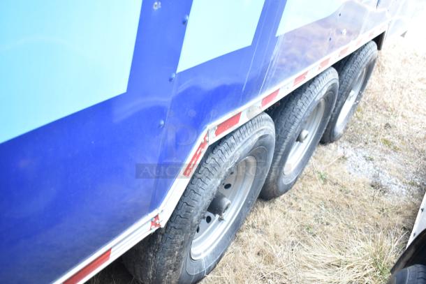 Rock Solid Cargo trailer tires, part of a 28' mobile kitchen. Blue body with white and red trim, triple axle.