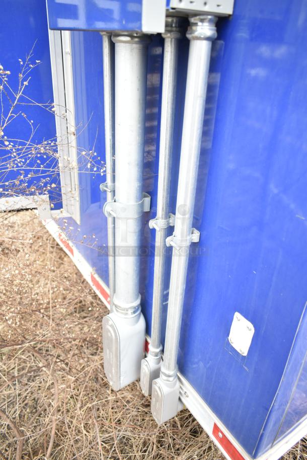 Blue exterior of the 2021 Rock Solid Cargo 28' mobile kitchen trailer showing electrical conduit and fittings.