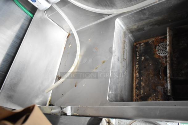 Interior view of a 2021 Rock Solid Cargo fast food trailer sink area, showing metal surfaces with visible wear and residue.