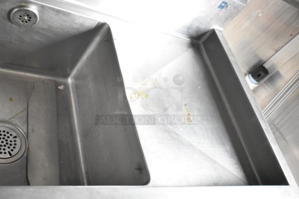 Stainless steel kitchen sink in Rock Solid Cargo fast food trailer, features visible wear. Part of a fully equipped mobile kitchen.