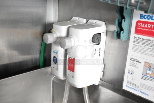 Ecolab dispenser system inside Rock Solid Cargo mobile kitchen trailer, used for sanitation and cleaning solutions.