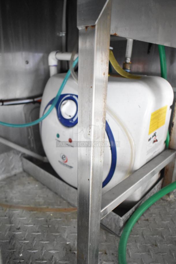 Interior view of 2021 Rock Solid Cargo mobile kitchen trailer, showcasing plumbing and utility connections with visible hoses.