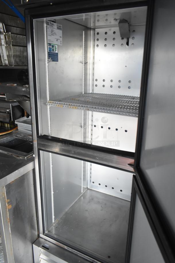 Interior view of a stainless steel commercial cooler compartment inside a 2021 Rock Solid Cargo fast food trailer.