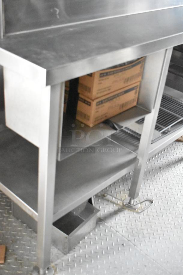 Metal shelf with boxes inside 2021 Rock Solid Cargo 28' fast food trailer. Sturdy construction, ideal for storage.