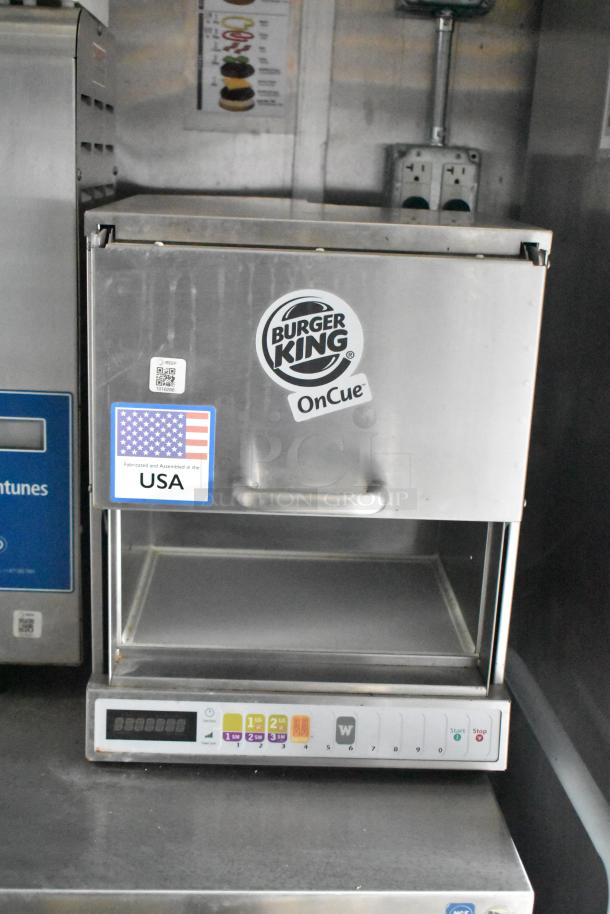 Burger King OnCue machine in Rock Solid Cargo trailer. Includes controls and USA fabrication sticker, ideal for mobile kitchen setup.
