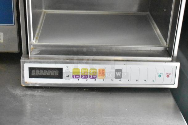 Control panel of a commercial kitchen appliance with program buttons for different food items, showing power levels and start/stop functions.