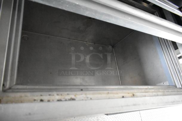 Interior view of a stainless steel compartment, part of the 2021 Rock Solid Cargo fast food trailer. Clean and spacious.