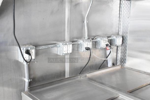 Electrically equipped interior of a 2021 Rock Solid Cargo 28' fast food trailer with multiple outlets and metal surfaces.