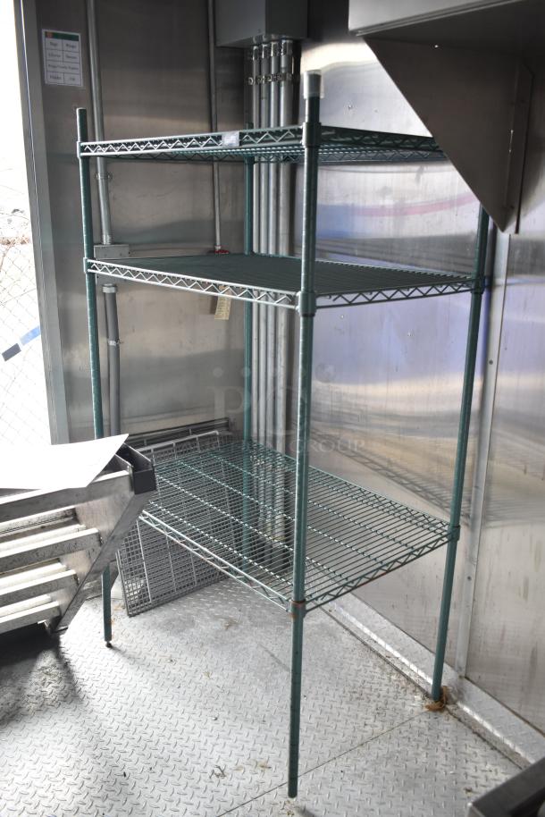 Steel shelving unit inside 2021 Rock Solid Cargo 28' fast food trailer kitchen, featuring commercial-grade equipment.