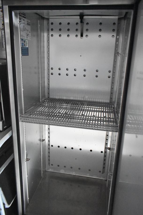 Interior view of a commercial-grade mobile kitchen trailer with metal shelving. Ideal for fast food operations.