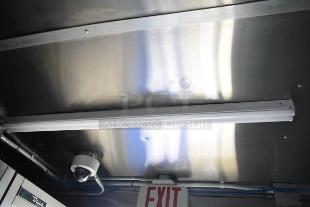 Interior view of 2021 Rock Solid Cargo mobile kitchen trailer. Features include ceiling light, security camera, and an EXIT sign.