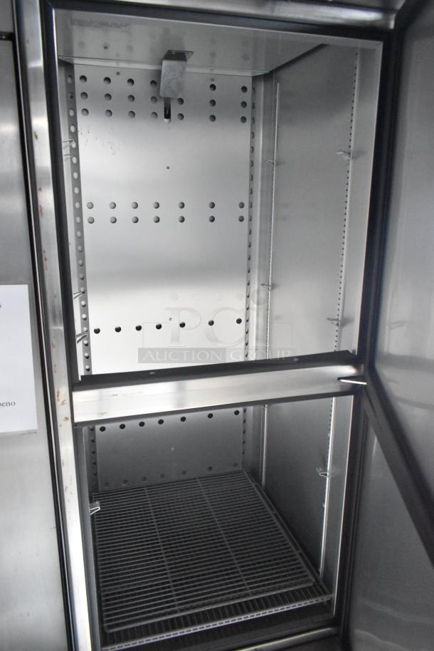 Interior of a stainless steel commercial appliance with perforated sides and a metal wire shelf.