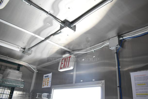 Interior view of a 2021 Rock Solid Cargo fast food trailer showcasing ceiling wiring and an exit sign.