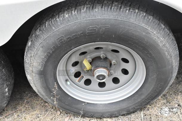 Single axle tire of 2020 ATX 8.5' x 24' trailer, featuring a Castle Rock ST radial tire with visible labels and markings.