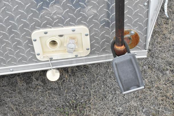 Exterior detail of 2020 ATX 8.5' x 24' Cold Food Trailer with metal texture, hose connection, and security lock.