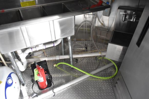 2020 ATX 8.5' x 24' trailer interior with stainless steel sink, fire suppression system, visible plumbing, and diamond plate flooring.