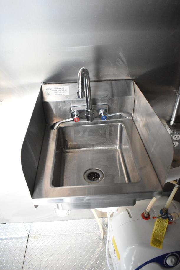 Stainless steel hand sink in 2020 ATX food trailer, features hot/cold faucets, NSF label, reflective clean surface.