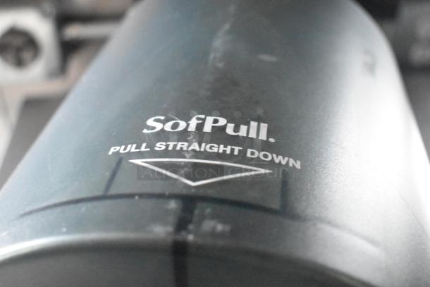 Paper towel dispenser labeled "SofPull, pull straight down," shown in close-up.