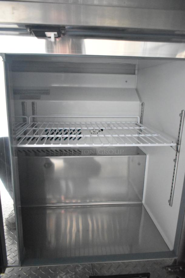 Interior of Arctic Air cooler with wire shelving inside a 2020 ATX 8.5' x 24' Cold Food Trailer. Clean and well-maintained.