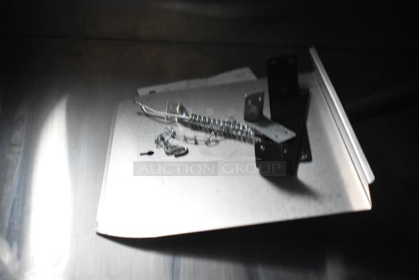 Metal components and brackets on a flat surface, possibly accessories or parts for installation inside the trailer.