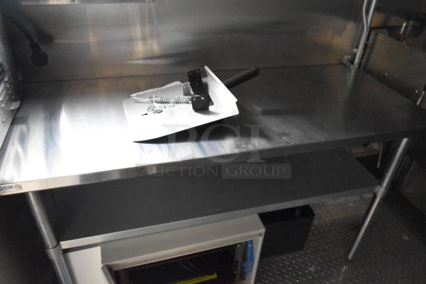 2020 ATX 8.5' x 24' food trailer interior with stainless steel table, visible IT/network cabinet, and clear surface reflection.