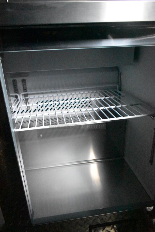 Interior view of Arctic Air cooler from a 2020 ATX food trailer, featuring a wire shelf and clean stainless steel surface.