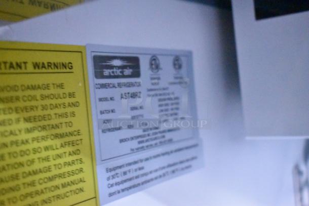 Arctic Air commercial refrigerator label, model AST48R, detailing batch, refrigerant info, and warnings for peak performance.