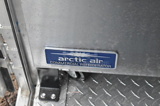 Arctic Air commercial refrigerator tag on ATX food trailer, featuring a steel surface with visible mounting hardware.