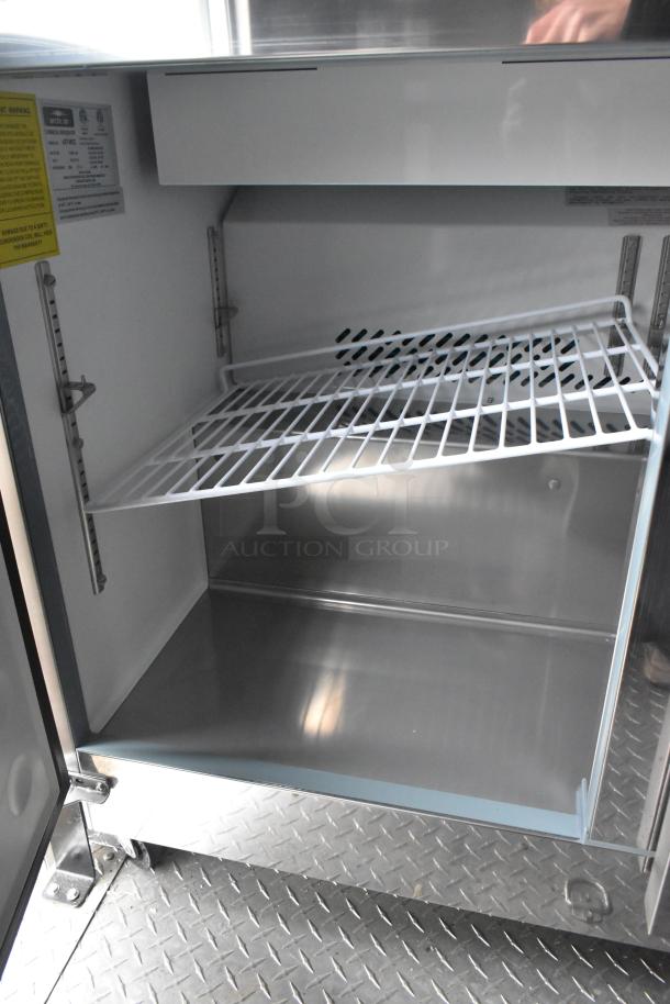 2020 ATX food trailer interior, featuring an open Arctic Air cooler with white wire shelves and labeled specifications panel.