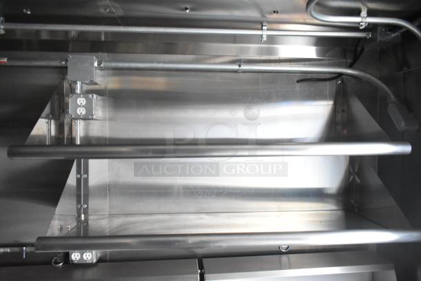 Interior view of a 2020 ATX 8.5' x 24' cold food and beverage trailer featuring stainless steel walls, an electrical outlet, and piping.