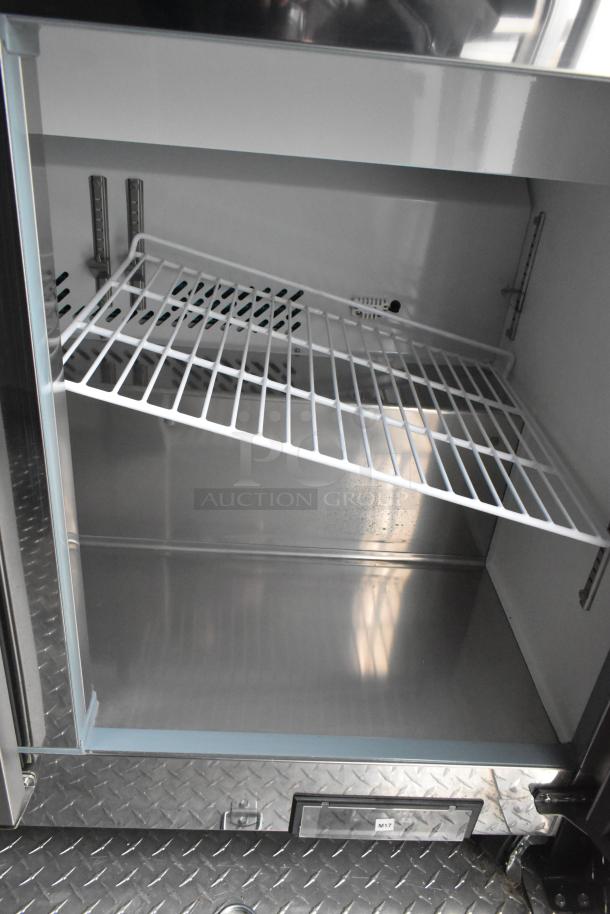 Empty Arctic Air cooler's interior with metal shelf inside ATX food trailer, showing diamond plate flooring.