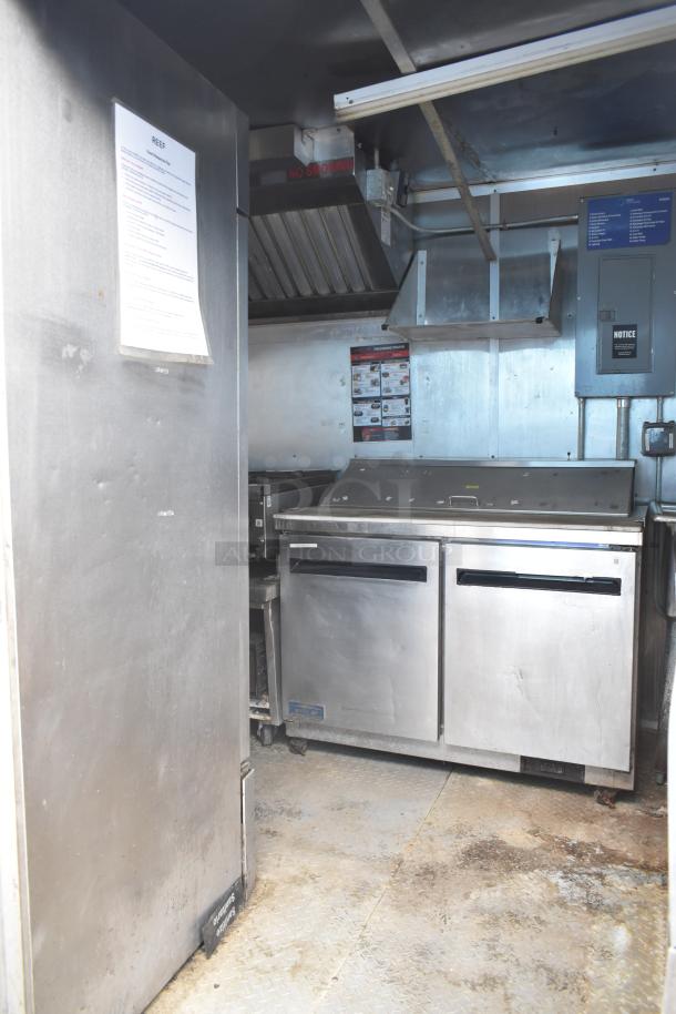 2019 Cruising Kitchens 8.5'x24' trailer interior with CaptiveAire grease hood, Arctic Air prep tables, coolers, and freezers.