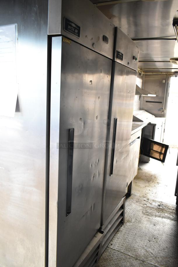2019 Cruising Kitchens trailer interior with Arctic Air coolers and freezer, showing CaptiveAire grease hood, in good condition.