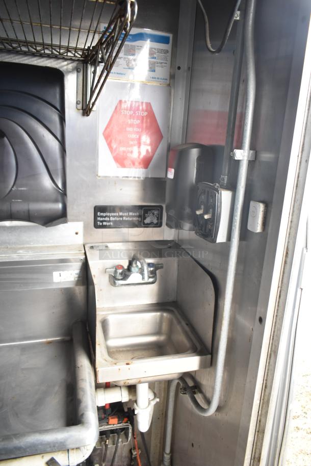 2019 Cruising Kitchens food trailer interior, features a stainless steel sink and wall signage with safety warnings.