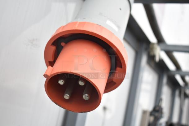 Close-up of a large industrial electrical plug on a Cruising Kitchens 8.5' x 24' food trailer, highlighting its robust build.