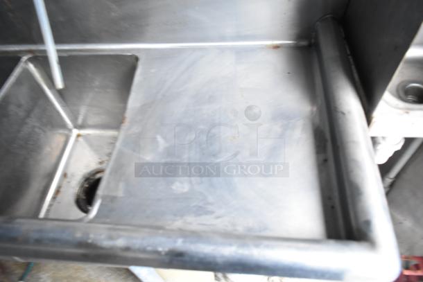 Close-up of a stainless steel sink, showing signs of use. Part of a 2019 Cruising Kitchens food trailer setup.