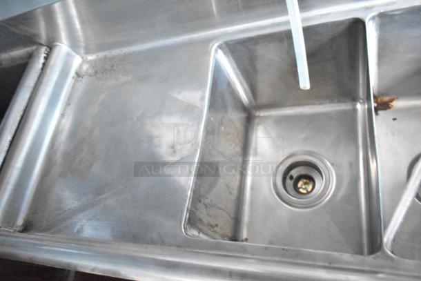 Stainless steel sink in the 2019 Cruising Kitchens food trailer, showing minor wear. Clean and functional condition.