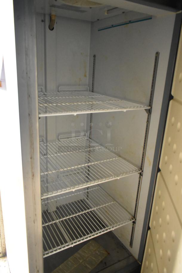 Interior view of a 2019 Cruising Kitchens trailer showing white wire shelves and clean surfaces, part of a cold food and beverage setup.