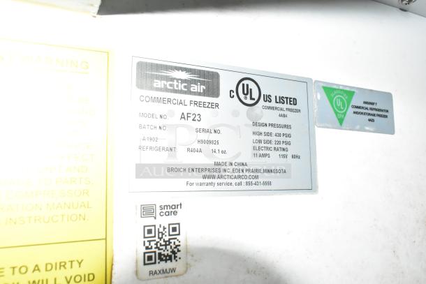 Close-up of Arctic Air commercial freezer label, model AF23, with batch number A1902, and refrigerant R404A details.