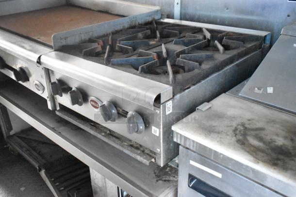 2019 Cruising Kitchens 8.5' x 24' trailer interior with Wells stove, showing multiple burners and knobs. Slight wear visible.
