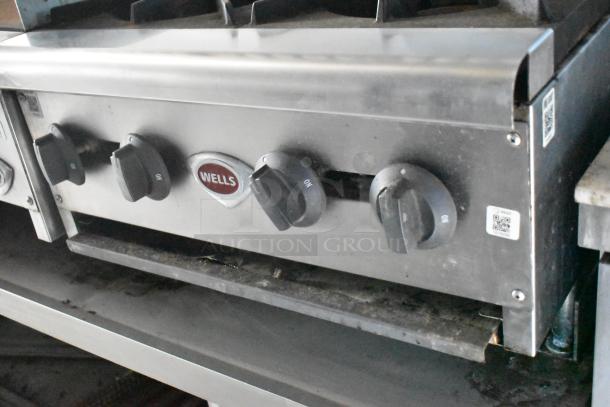 Wells stainless steel stovetop with control knobs, part of a Cruising Kitchens food trailer.