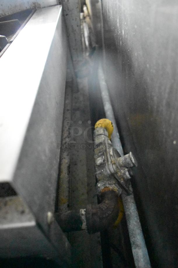 Close-up of a metal component in the 2019 Cruising Kitchens food trailer with visible wear, showing part of the grease hood system.