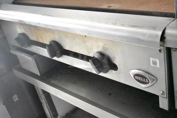Wells kitchen appliance with control knobs in a Cruising Kitchens trailer, showing signs of use.