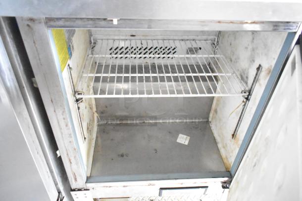 Interior of a used Arctic Air cooler in a 2019 Cruising Kitchens trailer, showing wire shelving and some wear.