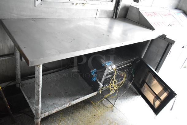 2019 Cruising Kitchens trailer interior with stainless steel prep table, Martin IT/Network Cabinet, and visible wiring.